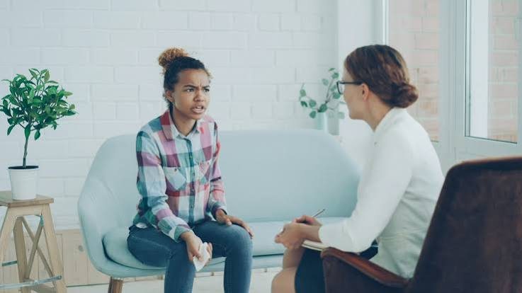 A young client talking with a counsellor in a bright, calm office