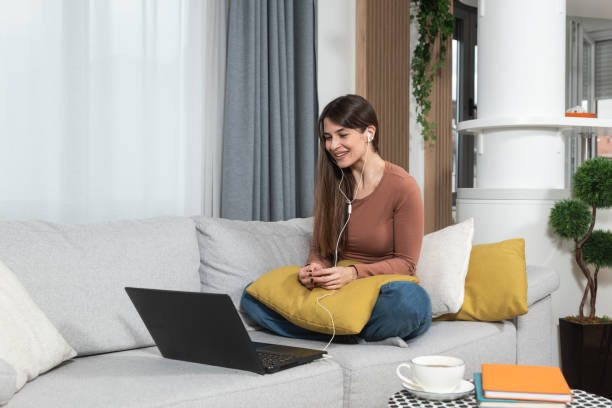 A woman having an online therapy session from her living room couch